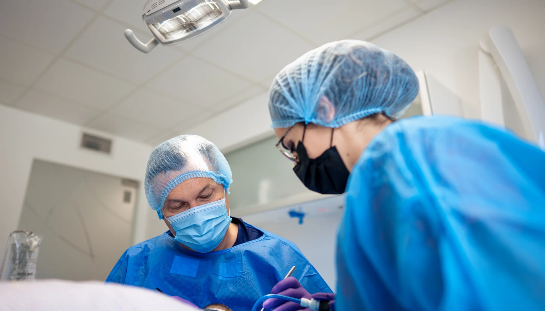 Deux chirurgiens-dentistes de Genève opérant ensemble sur un patient