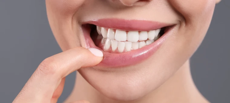 Patiente montrant son sourire du doigt après un soin